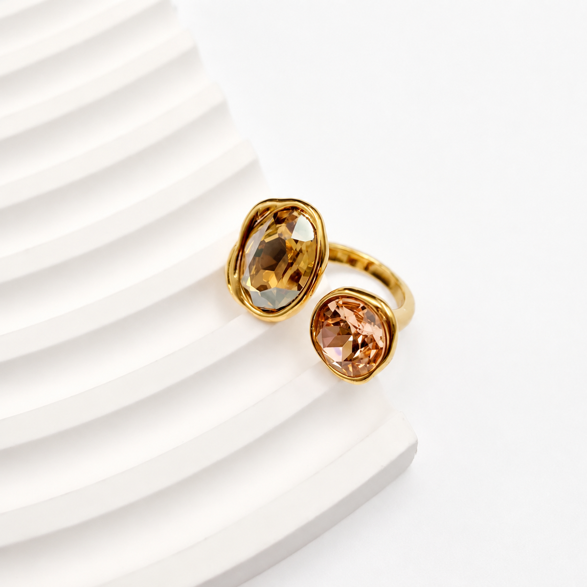 Open-front gold-tone ring with a larger oval amber-colored glass accent and a smaller round peach-colored glass accent