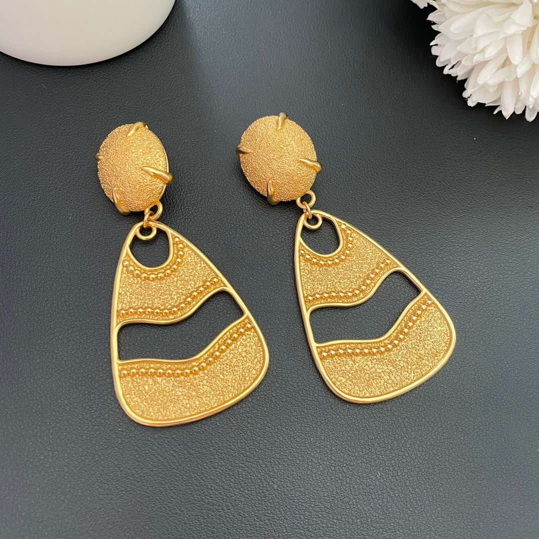 Front detail of gold-tone textured openwork drop clip-on earrings