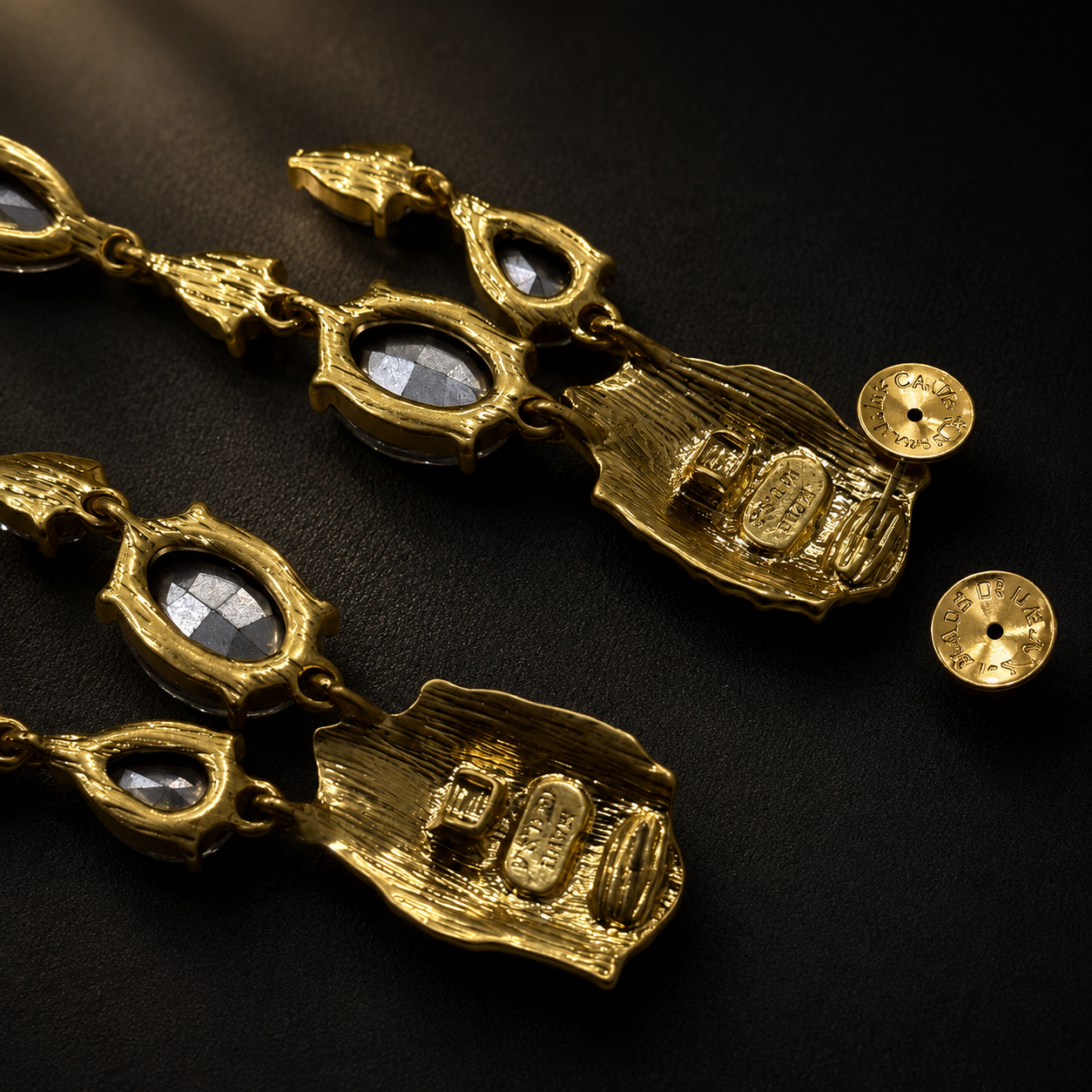 Back view of gold-tone crystal-style teardrop tassel earrings with stud and clip-on closures