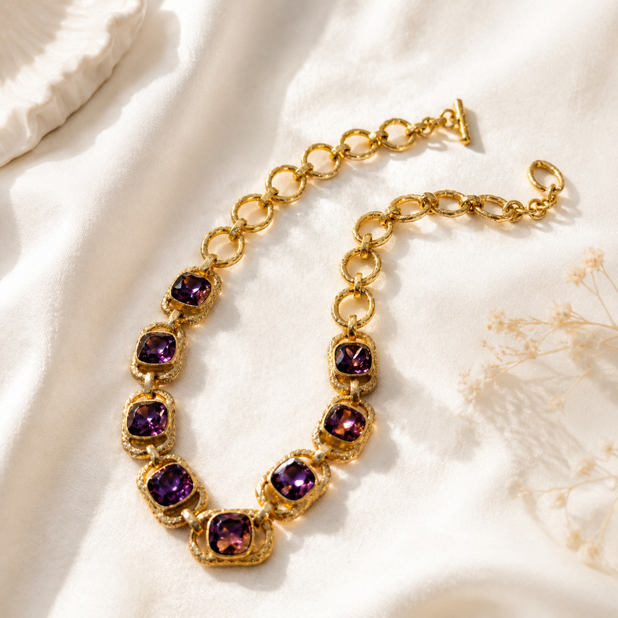 Gold-tone chain necklace with purple crystal-style-style accents angled view