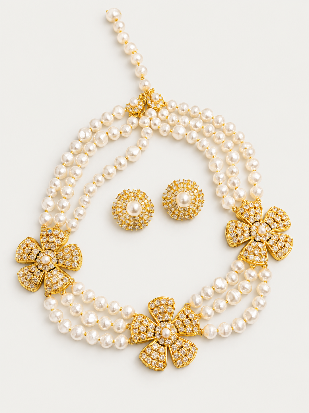Layered pearl-style necklace with three gold-tone flower stations and matching earrings