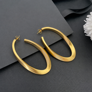 Styled view of 18K gold-plated vintage-inspired sculptural long stud earrings