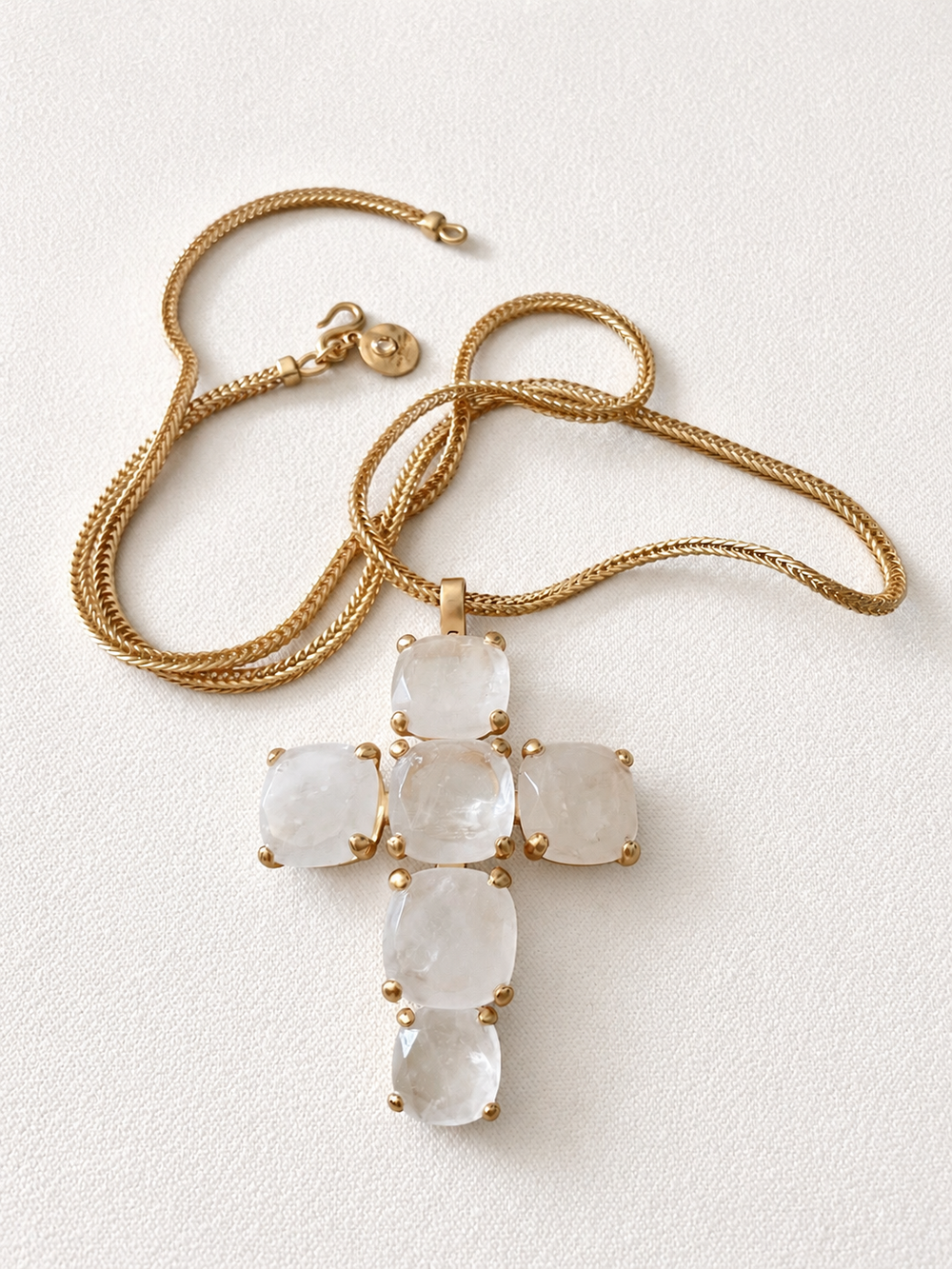 18K gold-tone crystal-style cross pendant necklace front view on ivory fabric