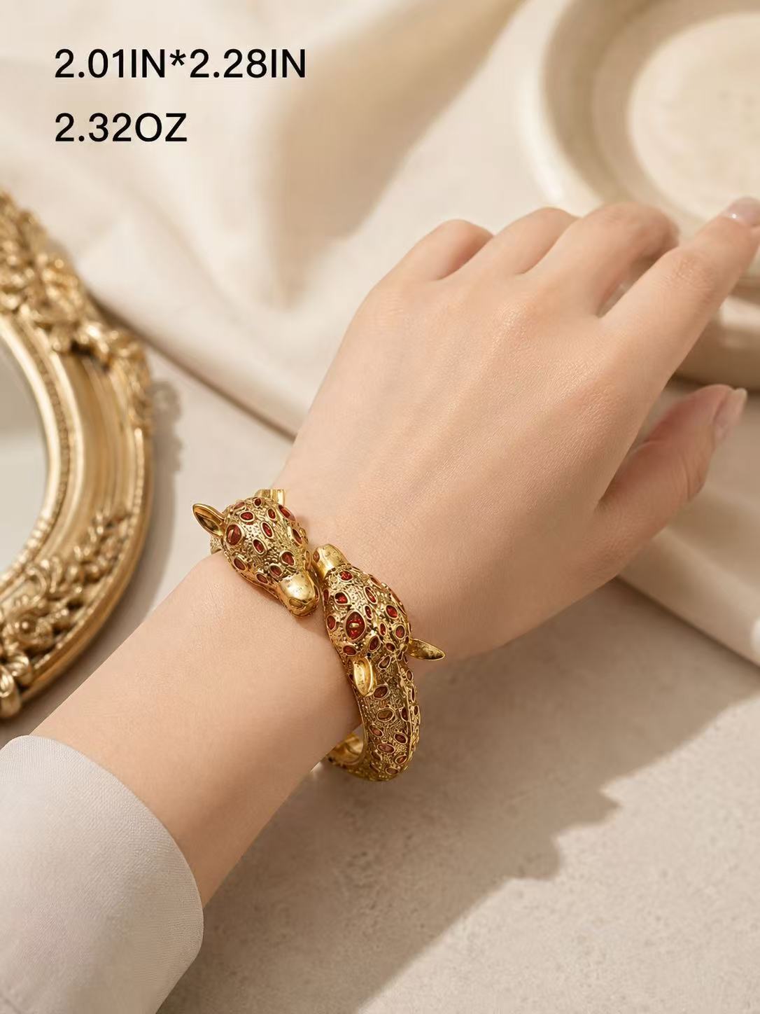 Gold-tone red stone-style leopard head open cuff bracelet worn on wrist