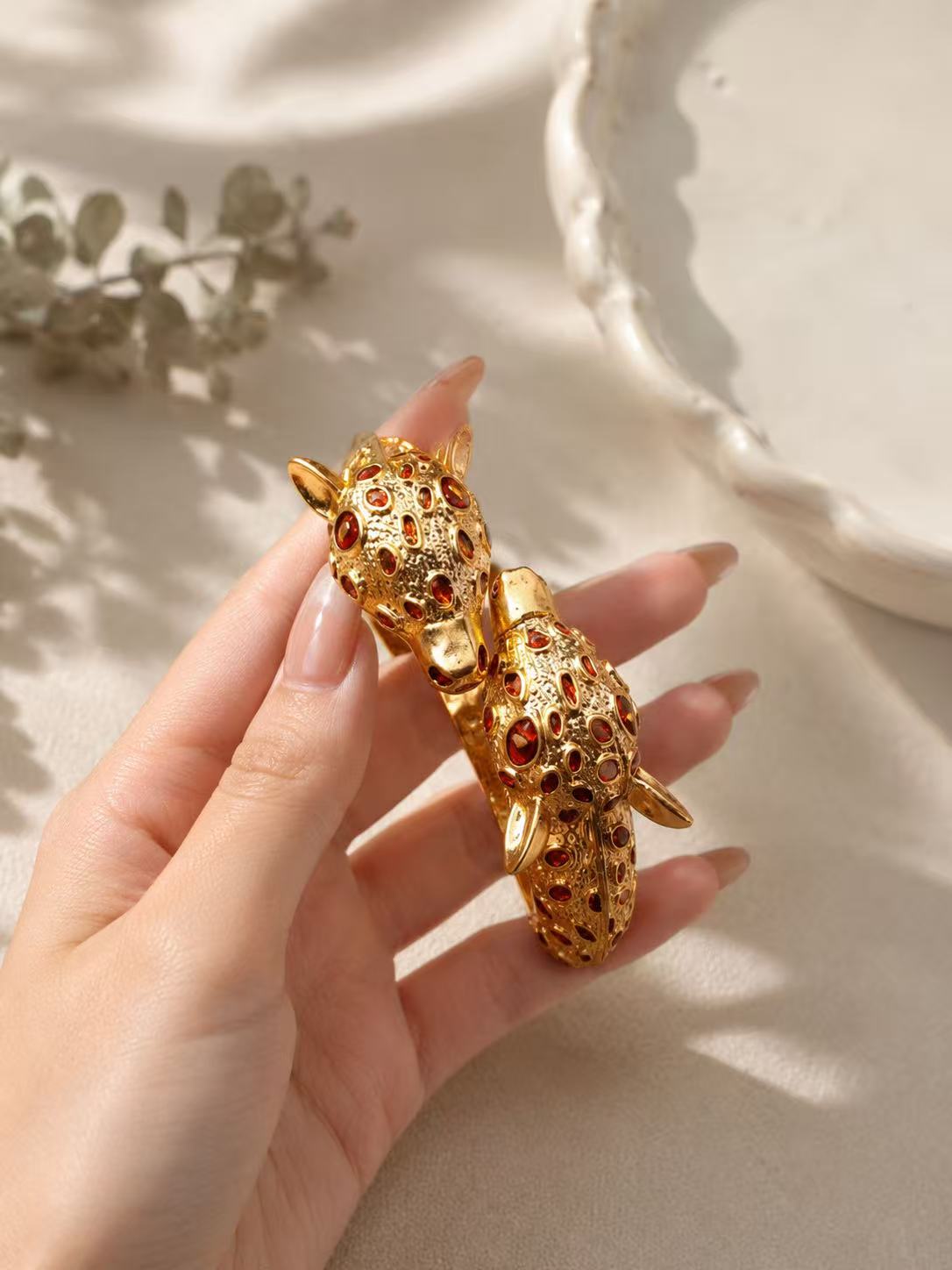 Gold-tone red stone-style leopard head open cuff bracelet detail view