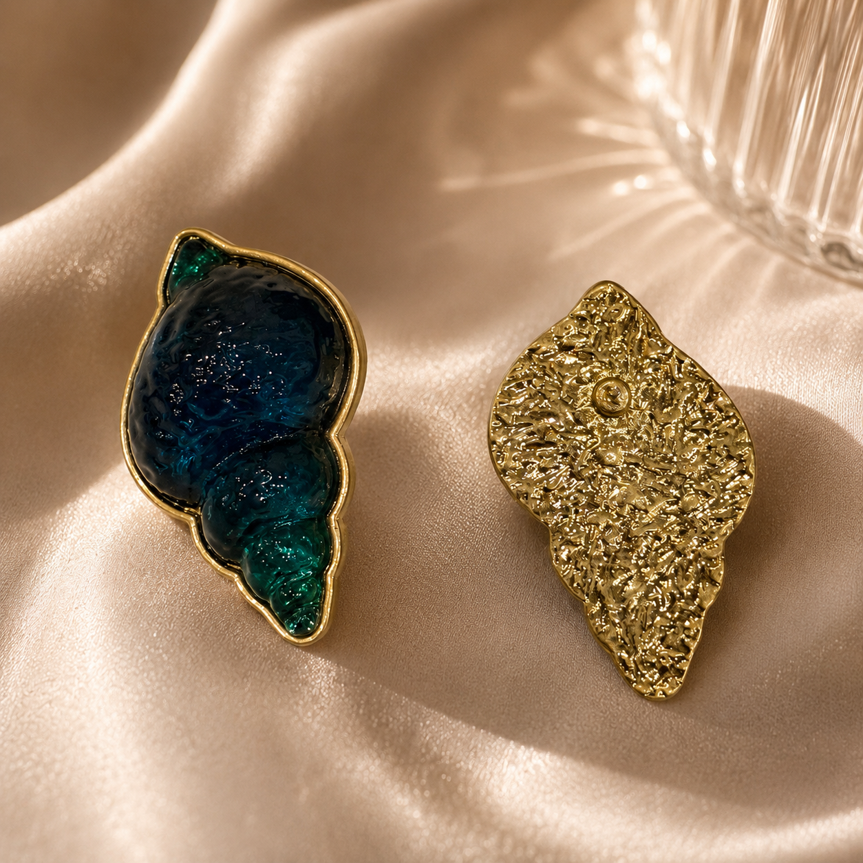 Front and back view of gold-tone teal conch shell-shaped stud earrings