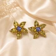 Purple gold-tone floral stud earrings with square crystal-style centers