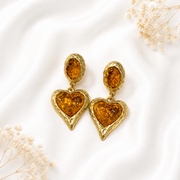 Orange glass heart drop earrings with a gold-tone setting.
