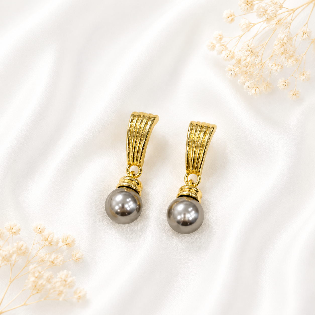 Gray pearl-style drop stud earrings with a gold-tone finish.