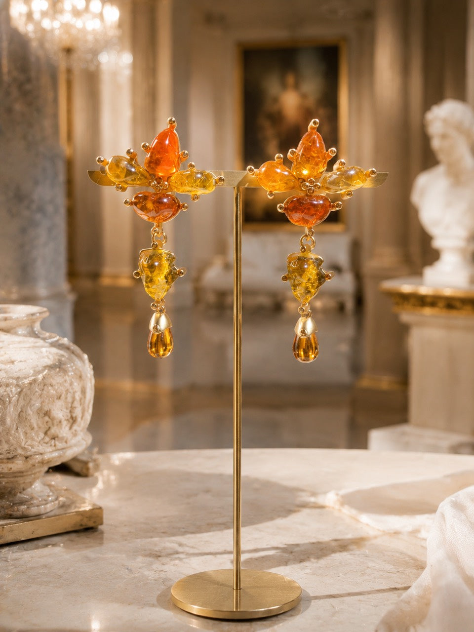 24K gold-tone copper floral clip-on earrings displayed on stand