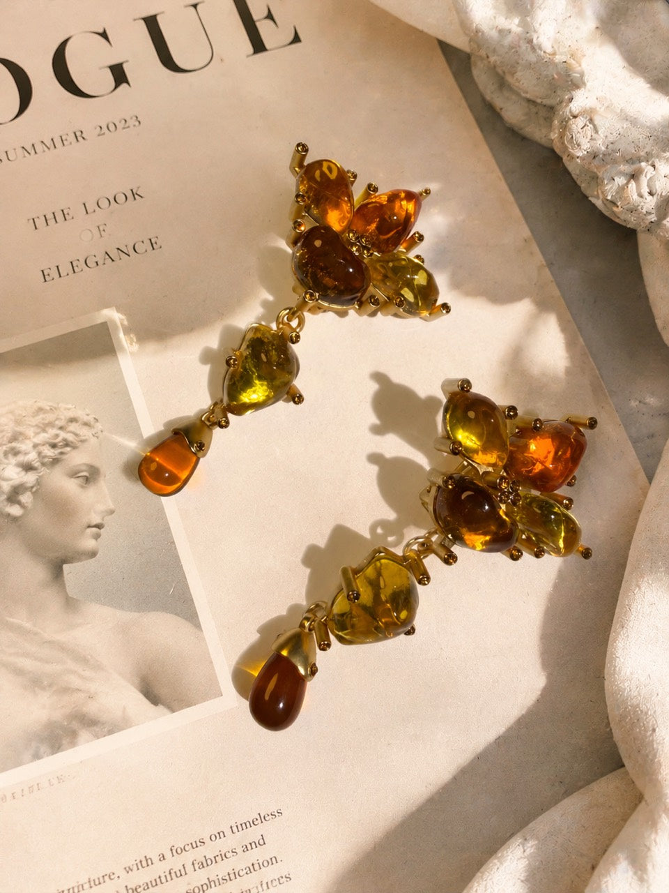 24K gold-tone copper floral clip-on earrings flat lay with amber-style drops