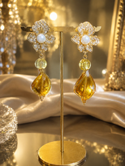Gold-tone floral clip-on drop earrings with amber-tone accents side view