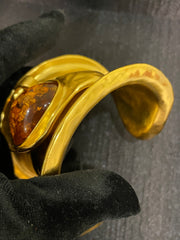 Angled detail view of vintage-inspired gold-tone cuff bracelet