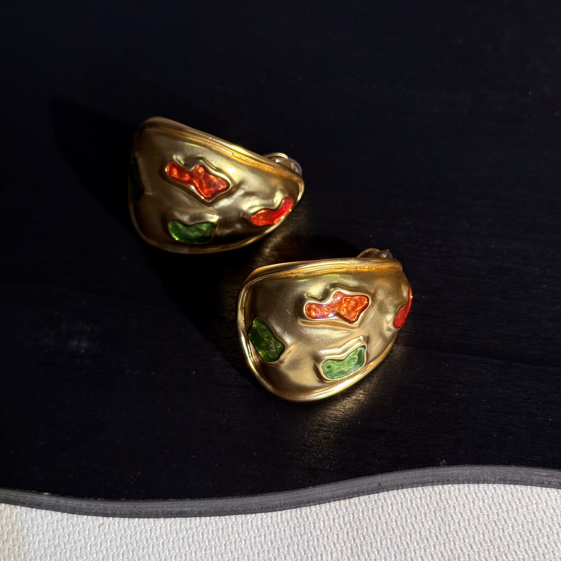 Sculptural gold-tone clip-on statement earrings with colorful accents front view