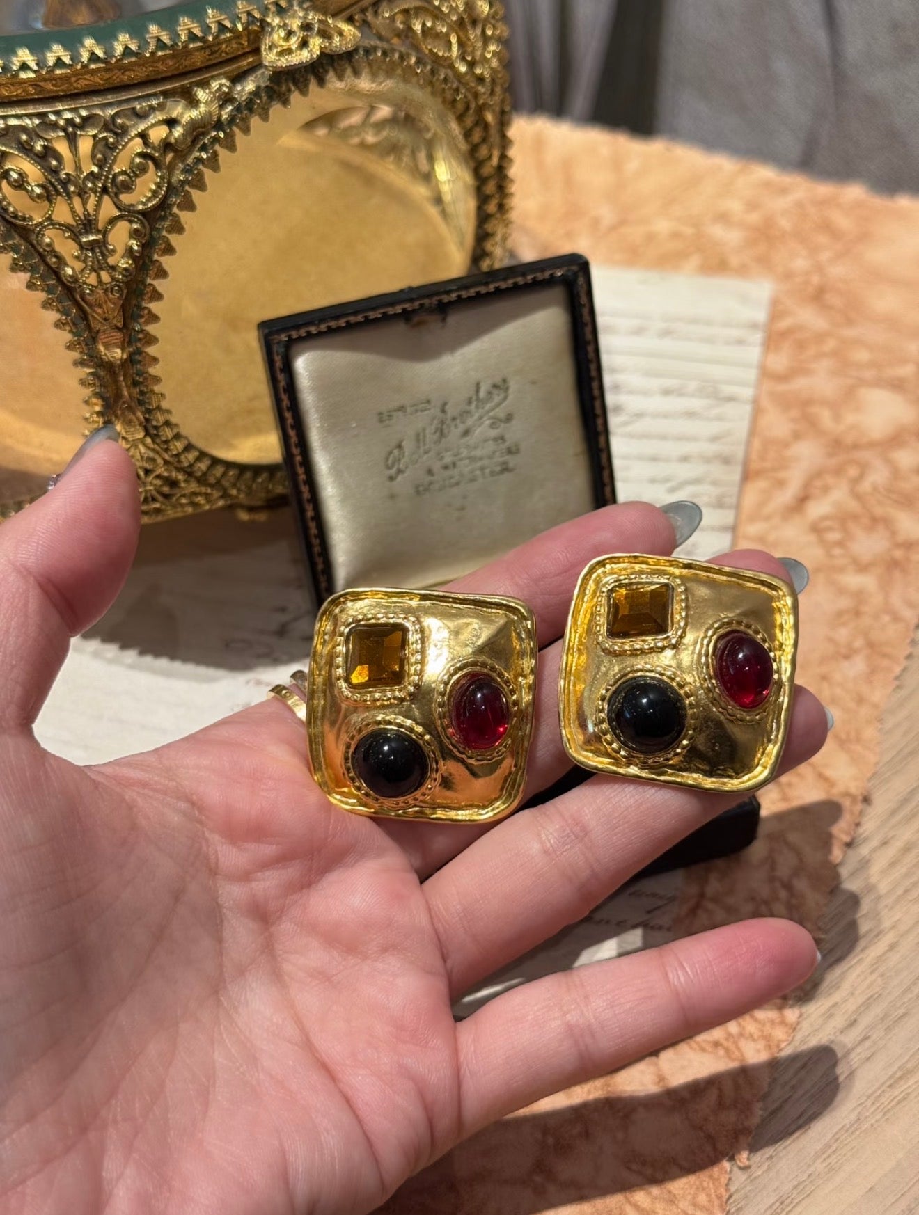 Gold-tone square clip-on statement earrings with red black and amber-tone accents