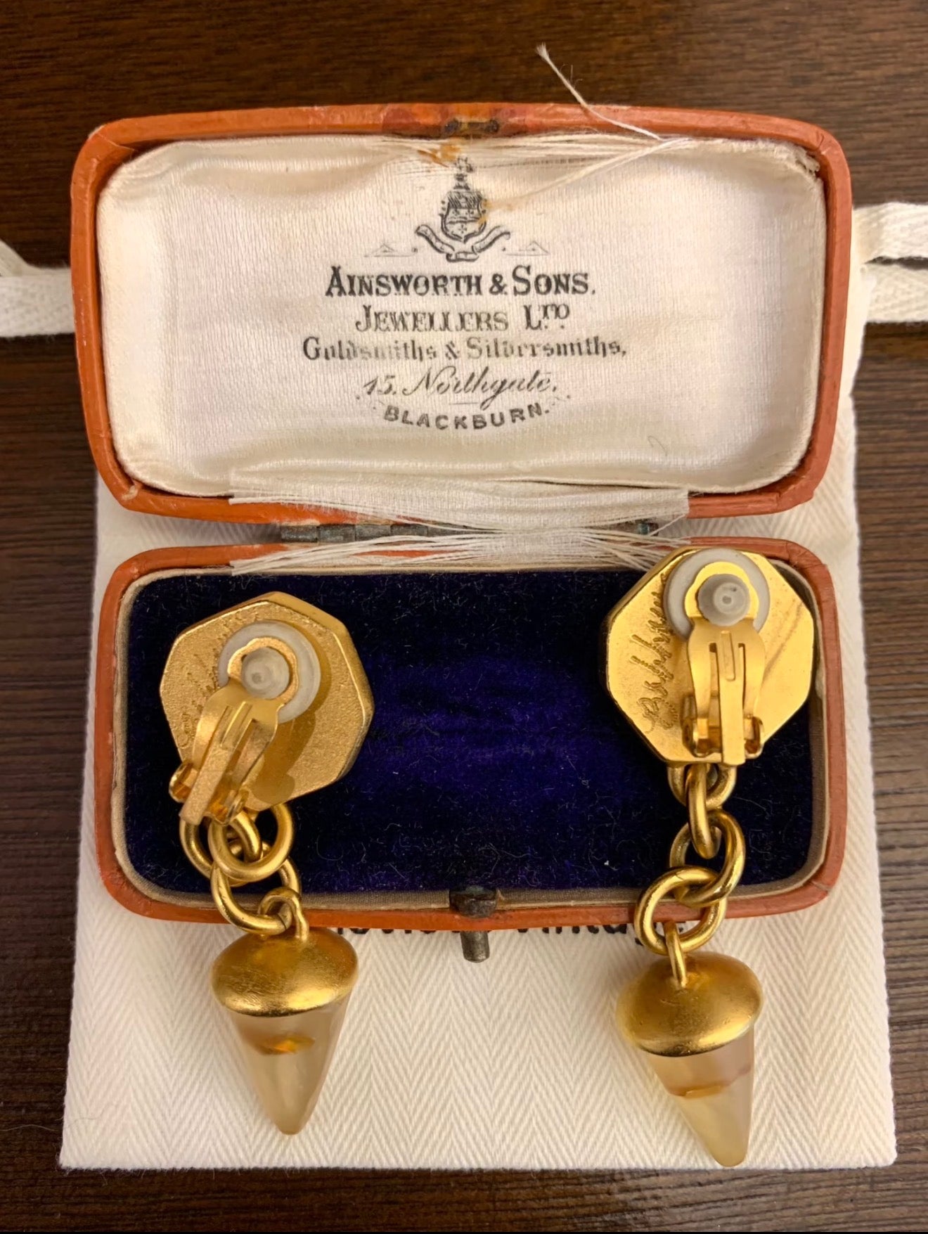 Back view of gold-tone clip-on drop earrings with chain links and cone drops