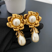 Pair of 18K gold-plated floral clip-on earrings with pearl-style centres and teardrop pendants