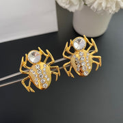 Front detail of the spider-shaped earrings and clear round stones