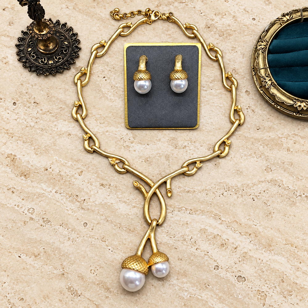 Gold-tone bamboo-link necklace with two pearl-style pendants and matching textured-cap stud earrings, shown as a complete set
