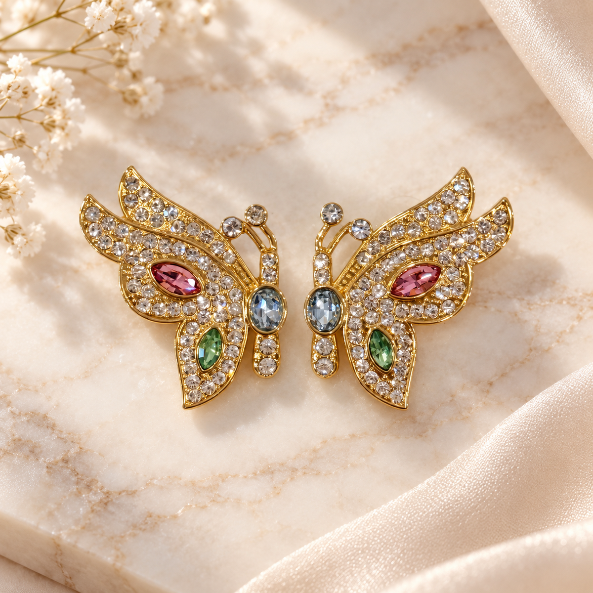 Pair of gold-tone butterfly stud earrings with clear, pink, green and pale blue faceted accents