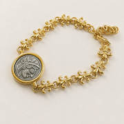 Detail view of the coin medallion and ornate floral bracelet links