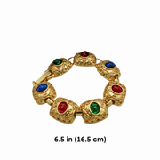 Gold-tone link bracelet with red, green and blue oval accents, shown with a 6.5 inch length label