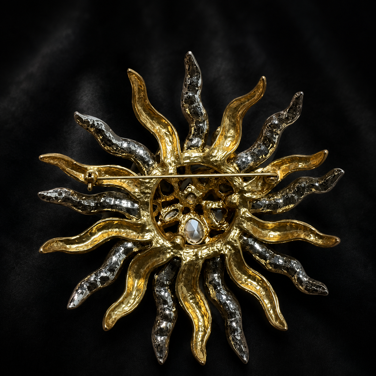 Back view of a two-tone sunburst statement brooch showing the pin fastening