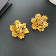 Back view of gold floral earrings showing the clip-on fastenings.