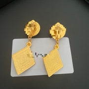 Back view of the red enamel and resin drop earrings showing the clip-on fastenings and textured gold-tone finish