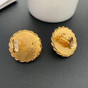 Back view of French-inspired medallion earrings showing the cushioned clip-on fastenings