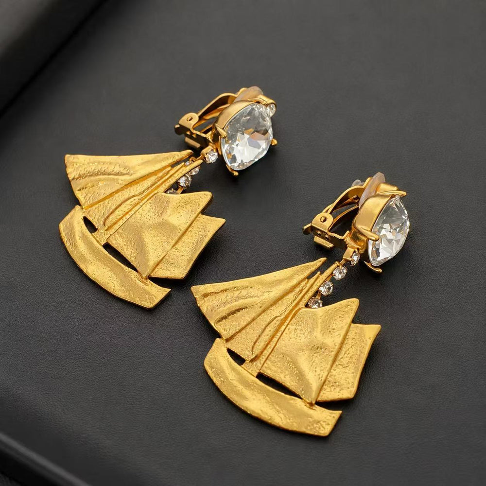 Close front and side view of 18K gold-plated sailboat clip-on earrings with clear faceted accents