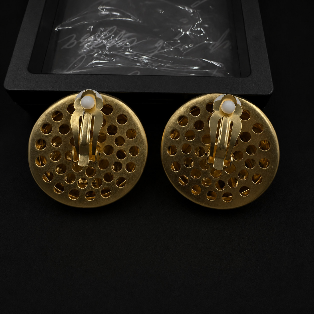 Back view of gold-tone lion head clip-on earrings with white comfort pads