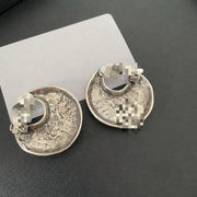 Back view of silver-tone crescent moon earrings showing cushioned clip-on fastenings