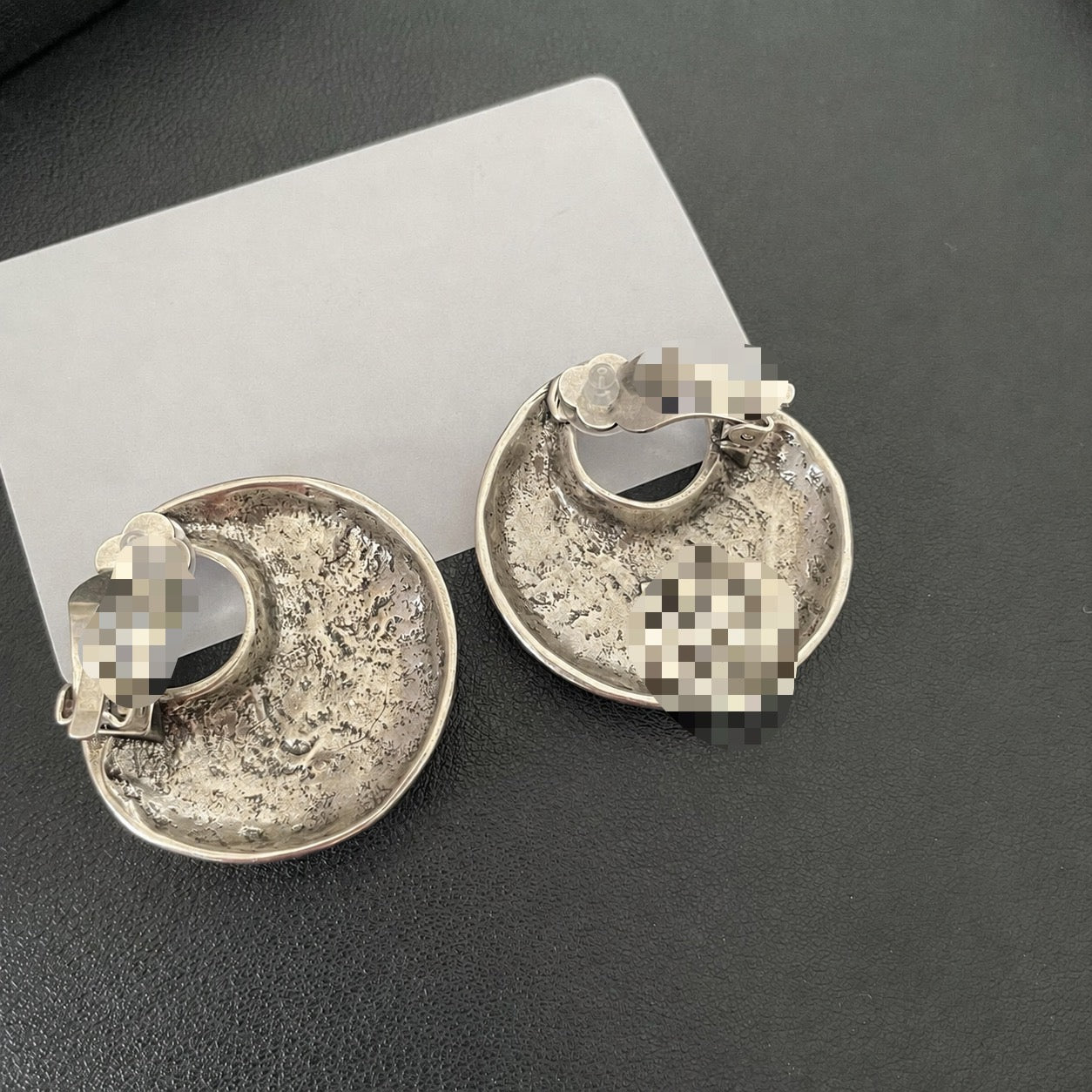 Back view of silver-tone crescent moon earrings showing cushioned clip-on fastenings