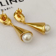 Close detail view of pearl-style pendant drops and post fastenings on gold-plated earrings