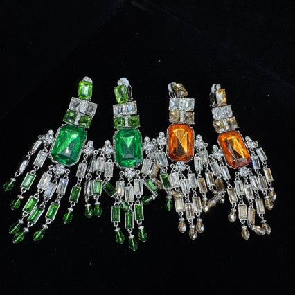 Green and amber geometric clip-on earrings shown together