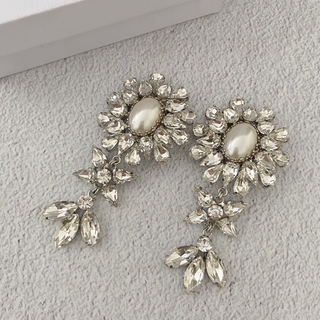 Full-length view of the floral pearl-style earrings and dangling leaf-shaped stone clusters