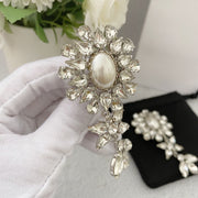 Close-up of the oval pearl-style centre and faceted floral stone surround