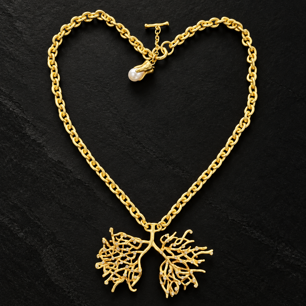 Matte gold-tone lucky tree statement necklace with openwork branching pendant, clear accents and pearl-style charm