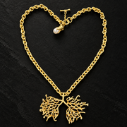 Matte gold-tone lucky tree statement necklace with openwork branching pendant, clear accents and pearl-style charm