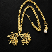 Reverse view of gold-tone openwork tree pendant necklace showing the branching texture and toggle fastening