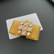Close-up of the clear square stones on the gold-tone mesh bracelet