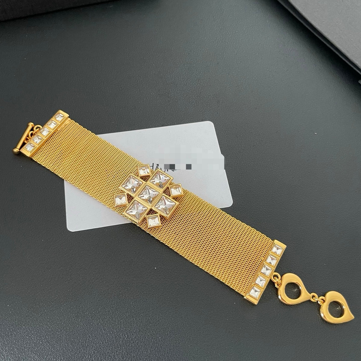 Full-length view of the gold-tone mesh bracelet and toggle closure