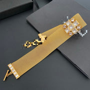 Gold-tone mesh choker laid flat showing the full band and toggle closure