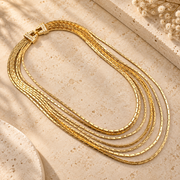 Gold-tone multi-strand chain necklace laid flat showing the layered chains and decorative side detail