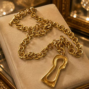 Close-up of the gold-tone chain links, toggle closure, and interchangeable keyhole pendant