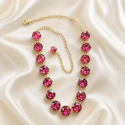 Gold-tone statement necklace with oversized rose pink faceted crystal-style accents
