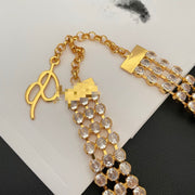 Close-up of the clasp, extender, and clear crystal-style rows on the gold-tone necklace