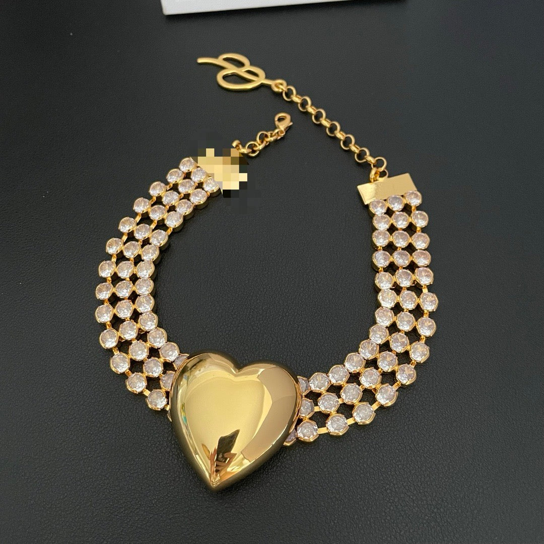 Full view of the gold-tone heart statement necklace with a multi-row crystal-style chain