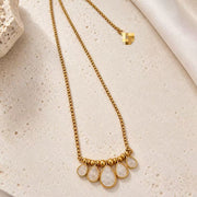 Full-length view of the 24K gold-plated teardrop crystal pendant necklace laid flat